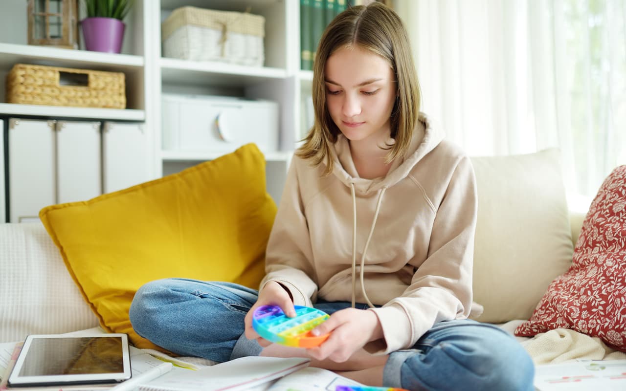 A female child with Autism playing with a fidget toy.